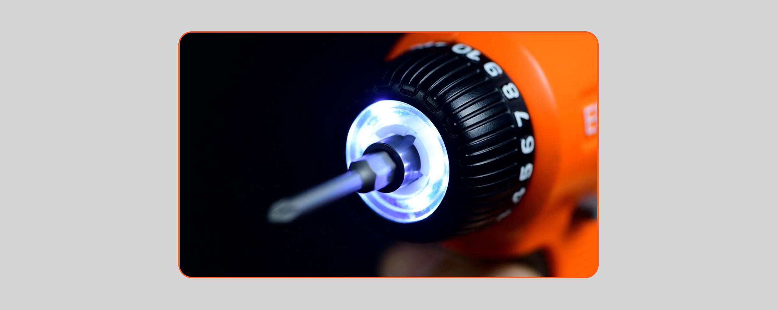 A close-up photograph of the front chuck of an orange ECOFORGE electric screwdriver, highlighting a bright circular LED ring light illuminating the inserted screwdriver bit and the numbered torque adjustment collar against a dark background.